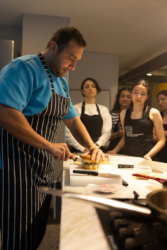 services-04 A professional chef in Samsun, Türkiye conducts a cooking workshop, demonstrating burger preparation.